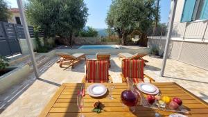 a wooden table with chairs and fruit on a patio at NIOS Luxury House & Studio in Vathi