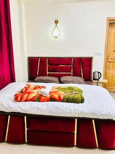 a bedroom with a bed with a red headboard at Secrets of Parvati in Kalgha