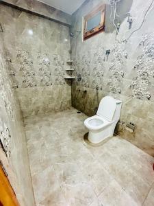 a bathroom with a toilet in a room at Secrets of Parvati in Kalgha
