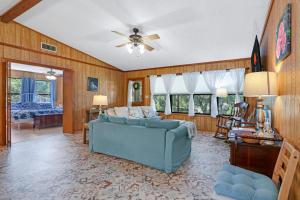 a living room with a blue couch and a ceiling fan at Miss Lilian's House in Wimberley