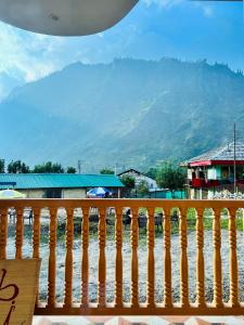 a wooden fence with a view of a mountain at Secrets of Parvati in Kalgha