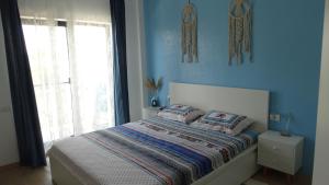 a bedroom with a bed with blue walls and a window at Sea Ray Studio in Năvodari +32 photos