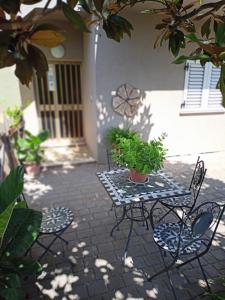 a patio with chairs and a table with plants on it at Marco - camere con bagno privato vicino al centro in Foligno