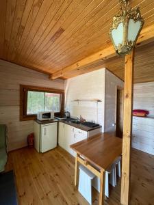 a kitchen with a wooden ceiling and a wooden table at Sodyba Duobys in Alanta