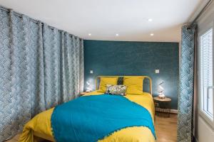 um quarto com uma cama azul e amarela em Bel appart rénové - la bohème em Hyères
