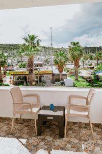 a balcony with chairs and a table and a view of a city at Pia Butik Otel Sığacık in İzmir
