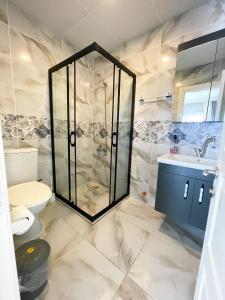 a bathroom with a shower and a toilet and a sink at Pia Butik Otel Sığacık in Izmir