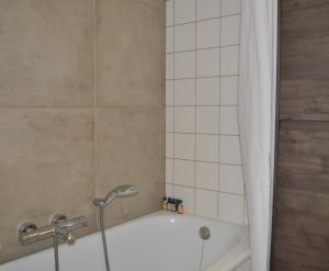 La salle de bains est pourvue d'une baignoire et d'une douche. dans l'établissement Villa Veerse Meer, à Kamperland