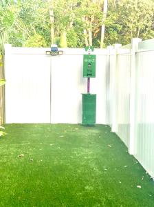 ein weißer Zaun mit einem grünen Meter in einem Hof in der Unterkunft Beach-town Pet-Friendly Downtown Home @ 10 acre Park-629 in Sarasota + 34 Fotos