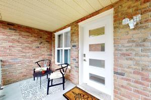 a porch with two chairs and a brick wall at Modern bright cozy 3bed 3bath Vacation house in Ajax, greater Toronto area GTA, ON, Canada in Ajax