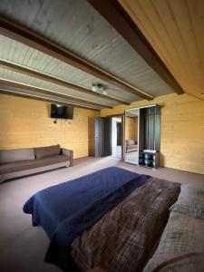 ein großes Schlafzimmer mit einem großen Bett und einem Sofa in der Unterkunft Кришталеві вершини in Worochta