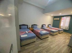 a room with three beds in a room at TAN OTEL in Mersin