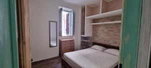 Dormitorio pequeño con cama y espejo en civico 44, en Bova Marina