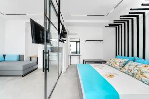 a living room with a bed and a tv at Mythodea Prive Luxury Suites in Chrysi Ammoudia