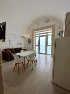 een keuken en een woonkamer met een tafel en stoelen bij Casa Roma 78 in Monopoli
