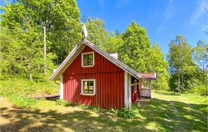 a red house in the middle of a field at Beautiful Home In Mrdaklev With 3 Bedrooms in Mårdaklev