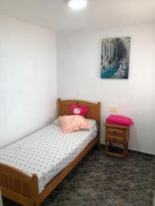 um pequeno quarto com uma cama e uma mesa em bungalows Santa Pola em Gran Alacant