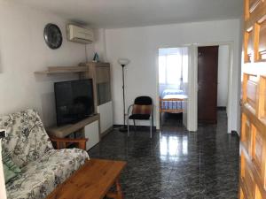 ein Wohnzimmer mit einem Sofa und einem TV in der Unterkunft bungalows Santa Pola in Gran Alacant