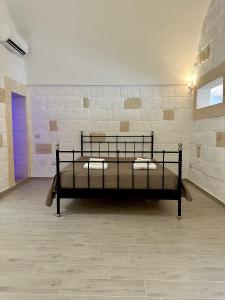 een bed in een kamer met een bakstenen muur bij Casa Roma 78 in Monopoli