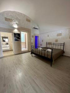een slaapkamer met een bed en een stenen muur bij Casa Roma 78 in Monopoli