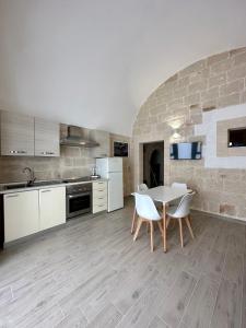 een keuken met een tafel en stoelen in een kamer bij Casa Roma 78 in Monopoli
