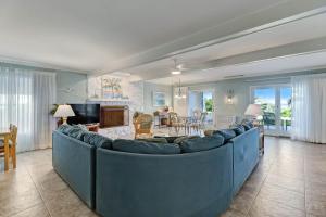 a living room with a blue couch and a dining room at Dog Friendly Beach House in Fernandina Beach