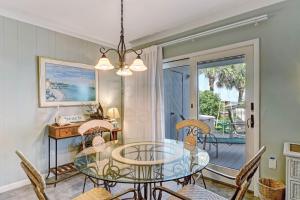 a dining room with a glass table and chairs at Dog Friendly Beach House in Fernandina Beach