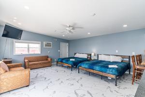 a living room with two beds and a couch at Boardwalk Sand & Surf Beach Hotel Oceanfront in Seaside Heights