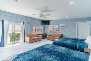 two beds in a room with blue walls at Boardwalk Sand & Surf Beach Hotel Oceanfront in Seaside Heights