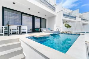 a house with a swimming pool and a patio at Mythodea Prive Luxury Suites in Chrysi Ammoudia +53 photos