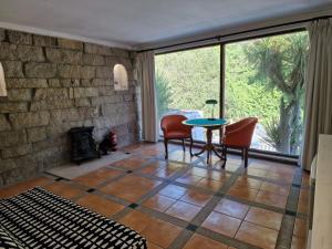 Dream corner by waterfalls, 20 min to Oporto في Parada: غرفة معيشة مع طاولة وكراسي ومدفأة