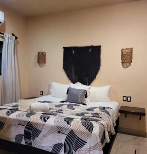 a bedroom with a bed with a black and white comforter at Suites Villas el Jardín in Holbox Island