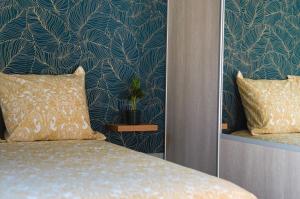 ein Schlafzimmer mit einem Bett und einer blau-grünen Wand in der Unterkunft The Sweetness of Champagne, Hyper-Centre in Reims