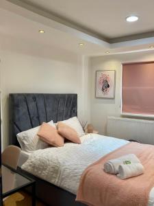 um quarto com uma cama grande com duas almofadas em SHOREDITCH ROOMS - Apartments and Rooms in The City em Londres