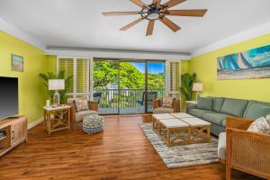 a living room with a couch and a tv at Step to beach New Quiet Kiahuna Plantation Remodeled 2 bedroom condo with AC in Koloa