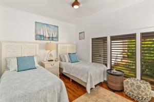 a bedroom with two beds and a window at Step to beach New Quiet Kiahuna Plantation Remodeled 2 bedroom condo with AC in Koloa