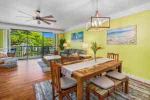 a dining room and living room with a table and chairs at Step to beach New Quiet Kiahuna Plantation Remodeled 2 bedroom condo with AC in Koloa