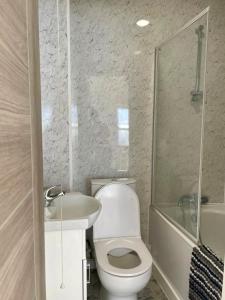 uma casa de banho com um WC, um lavatório e um chuveiro em SHOREDITCH ROOMS - Apartments and Rooms in The City em Londres