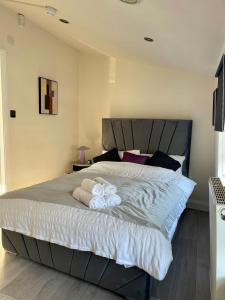 um quarto com uma cama grande e toalhas em SHOREDITCH ROOMS - Apartments and Rooms in The City em Londres