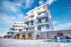 a white building with a swimming pool in front of it at Olivia By Atlantic in Agadir