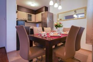 a dining room with a wooden table and chairs at Apartman Kristijan in Viskovo