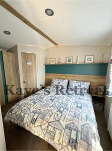 ニューキーにあるKayes Retreat Three bed caravan Newquay Bay Resort Quieter area of parkのベッドルーム(カラフルなキルトのベッド付)