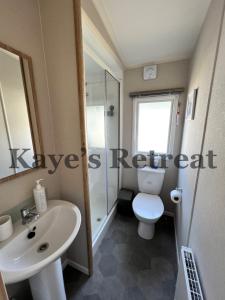 Łazienka z białą toaletą i umywalką w obiekcie Kayes Retreat Three bed caravan Newquay Bay Resort Quieter area of park w Newquay