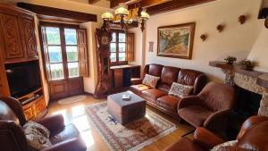 uma sala de estar com sofás de couro e uma televisão em Can Vila Rupit em Rupit