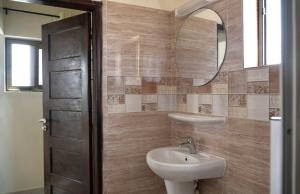 コトヌーにあるRésidence des Amazones Appartement 2のバスルーム(洗面台、鏡付)
