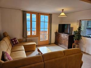 a living room with a couch and a television at Chalet Aargovia in Wengen
