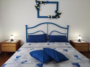 a bedroom with a blue bed with blue pillows at Il Villino in Platamona
