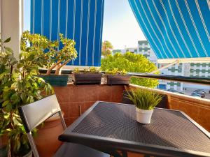 a table and chairs on a balcony with potted plants at Mi rincón de Rota in Rota