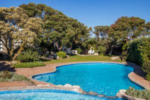 a swimming pool in a yard with trees at 29@Whale Rock Estate in Hermanus