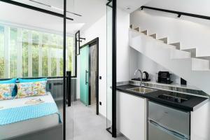 a kitchen with a bed and a sink in a room at Mythodea Prive Luxury Suites in Chrysi Ammoudia